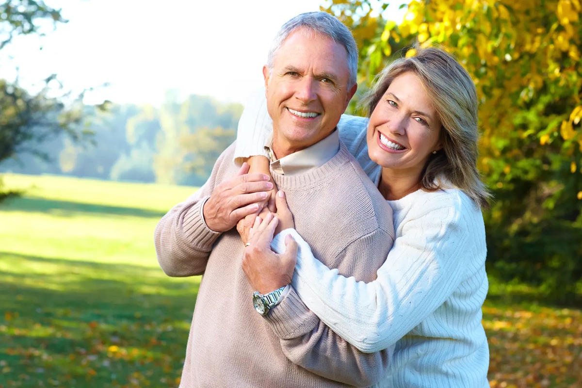 An older couple embracing outdoors