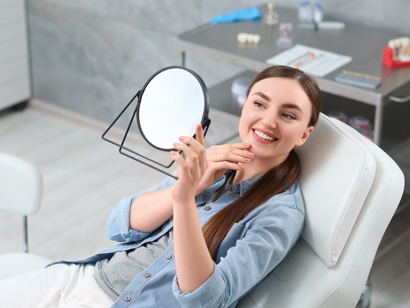 A patient looking at her restored teeth in a mirror