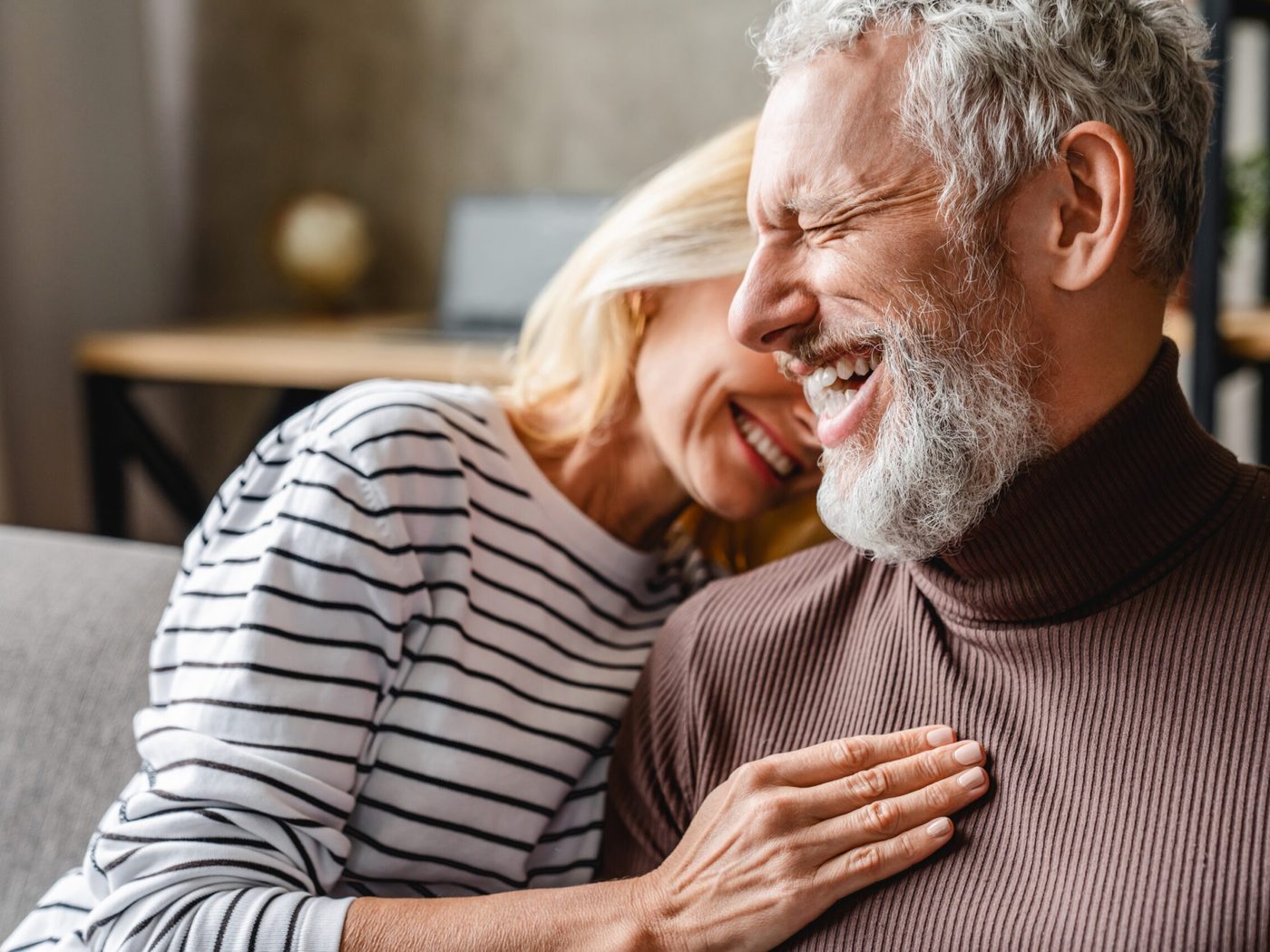 An older couple laughing together at home