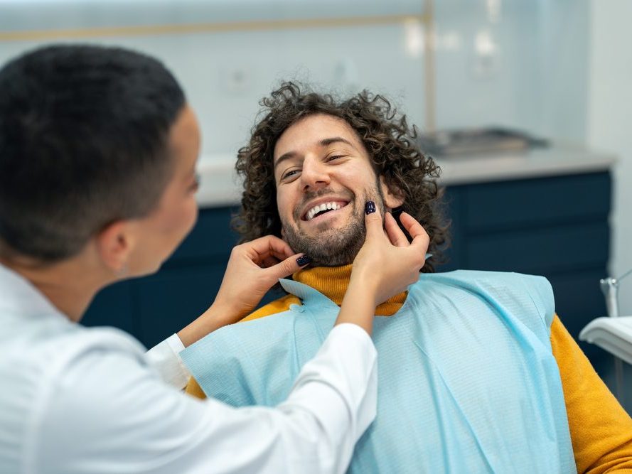 A patient smiling during a check-up at the dental clinic