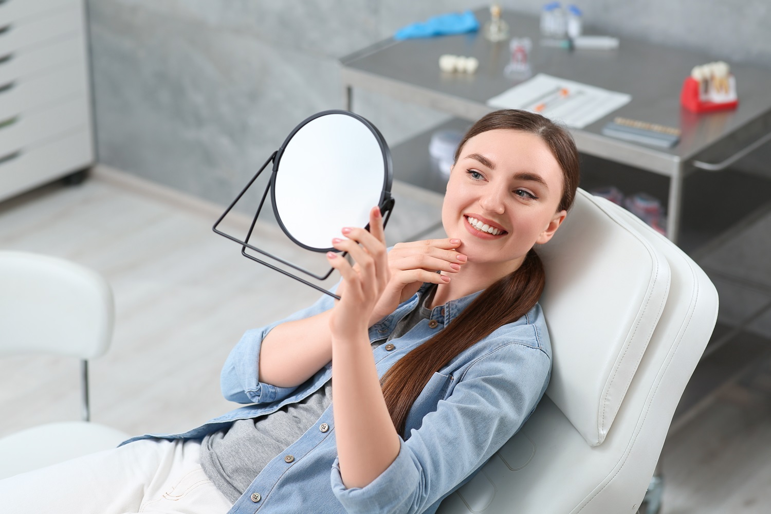 Young woman looking at her teeth - Dental Crowns in Rancho Bernardo