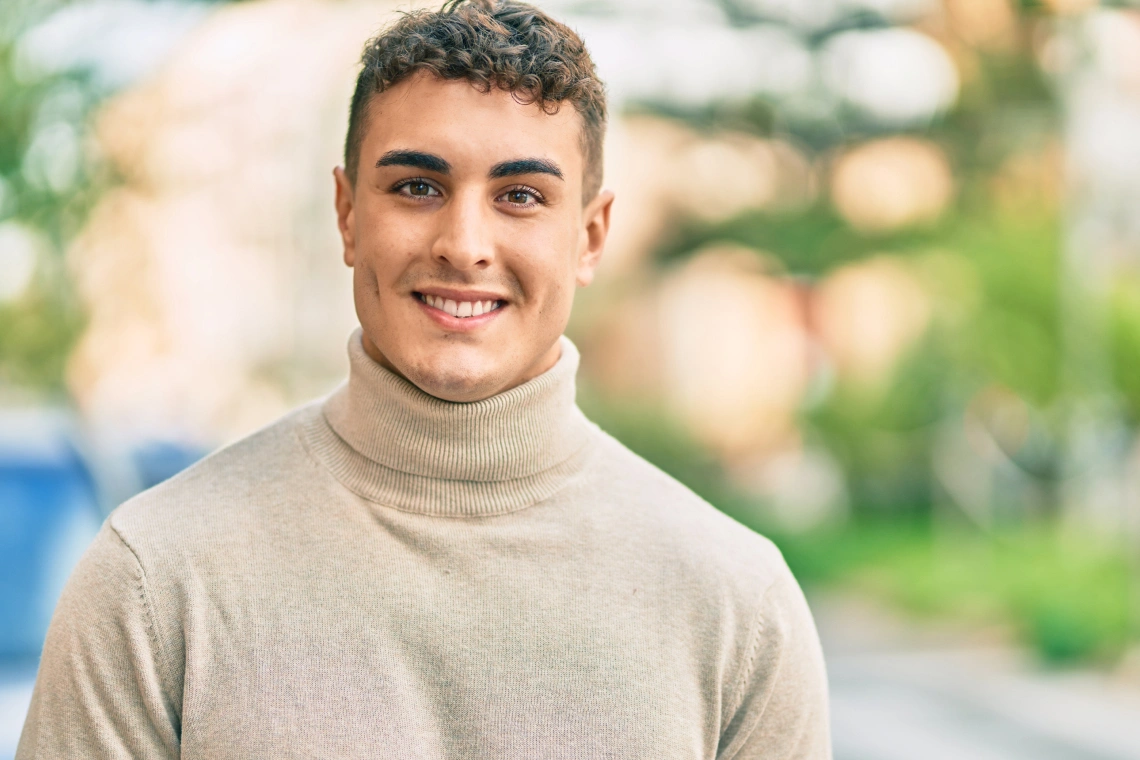 A dentist gently examining a patient's mouth in a modern dental clinic while the patient looks concerned but reassured.