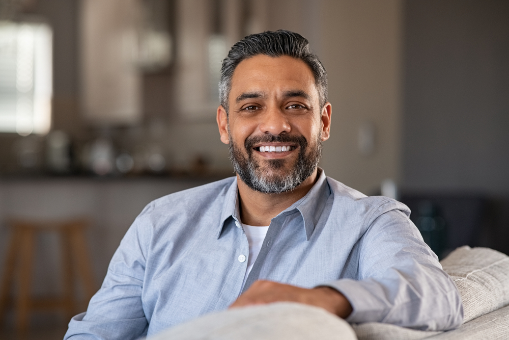 Smiling man with bright teeth after teeth whitening - Rancho Bernardo Dentist Middle-aged man with beard smiling confidently at home, showing results of teeth whitening - Rancho Bernardo Dentist